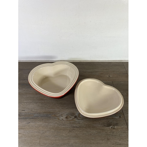 298 - A Le Creuset red glazed stoneware heart shaped 2.4L casserole dish and lid