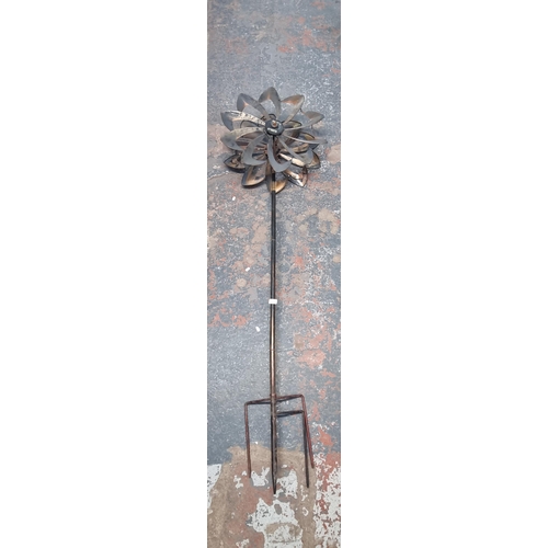 547 - A metal garden wind spinner in the form of a flower - approx. 203cm high