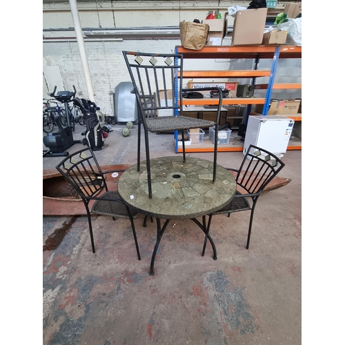 569 - A four-piece metal patio set comprising cast stone top table and three rattan effect chairs