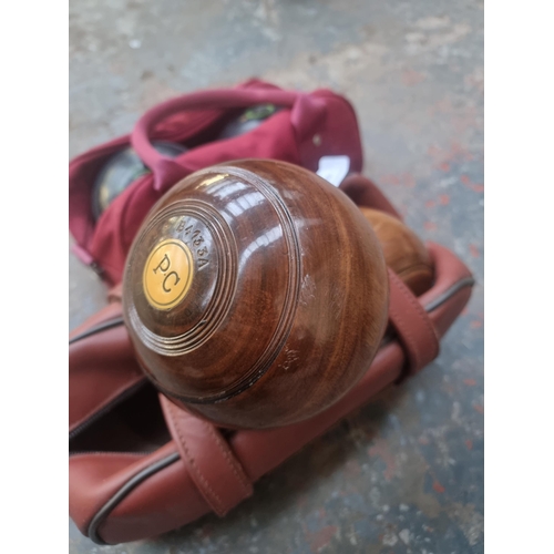 572 - Two cased pairs of crown green bowls, one lignum vitae and one Taylor Elite