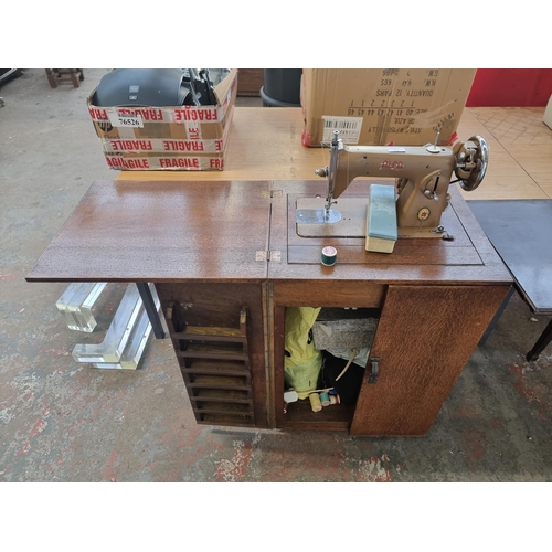 710 - A Sewing machine cabinet containing ALFA electric sewing machine with foot pedal, patterns, cotton, ... 