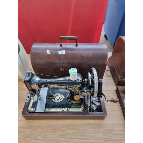 713 - A cased Singer hand crack sewing machine with accessories - serial number Y2120995