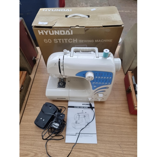 717 - A boxed Hyundai sixty stitch electric sewing machine with foot pedal and instruction manual