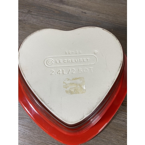 298 - A Le Creuset red glazed stoneware heart shaped 2.4L casserole dish and lid