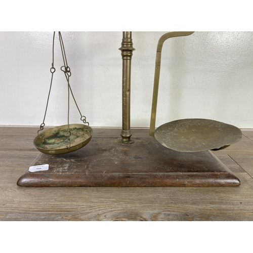 309 - A set of early 20th century brass weighing scales on mahogany plinth - approx. 53cm high x 45cm wide... 