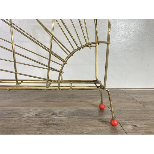 323 - A mid 20th century brass and red plastic atomic magazine rack - approx. 54cm high x 43cm wide x 16cm... 