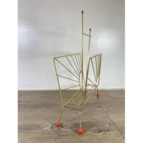 323 - A mid 20th century brass and red plastic atomic magazine rack - approx. 54cm high x 43cm wide x 16cm... 