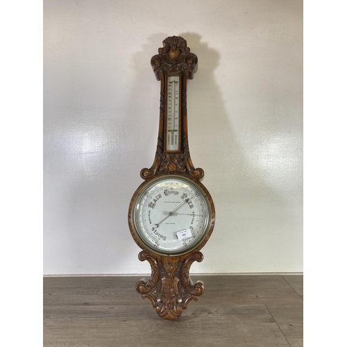 483 - An early 20th century Lloyd, Payne & Amiel of Manchester heavily carved oak barometer with porcelain... 