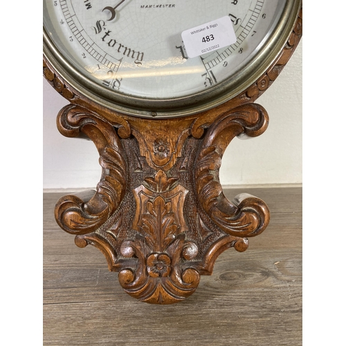 483 - An early 20th century Lloyd, Payne & Amiel of Manchester heavily carved oak barometer with porcelain... 