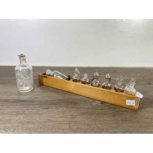 499A - A collection of early/mid 20th century glass apothecary bottles with beech stand