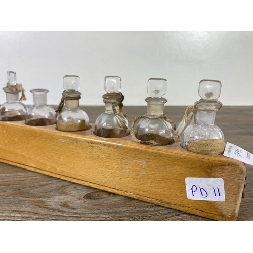 499A - A collection of early/mid 20th century glass apothecary bottles with beech stand