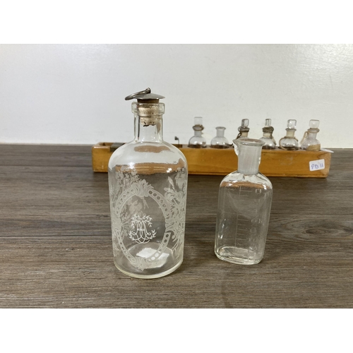 499A - A collection of early/mid 20th century glass apothecary bottles with beech stand