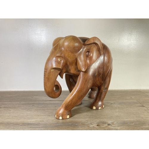 507 - A carved teak elephant statue - approx. 37cm high x 21cm wide x 40cm deep