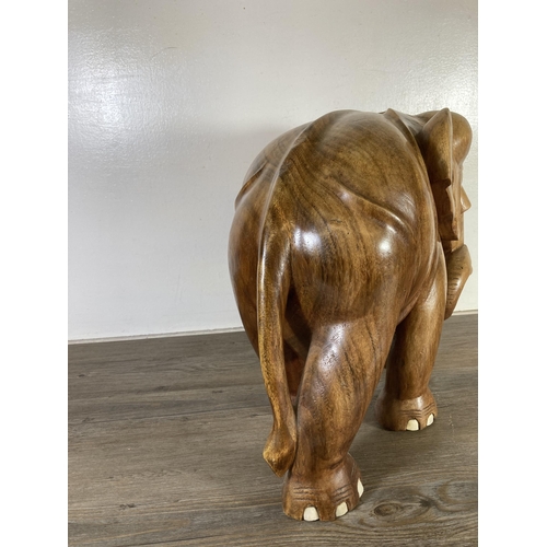 507 - A carved teak elephant statue - approx. 37cm high x 21cm wide x 40cm deep