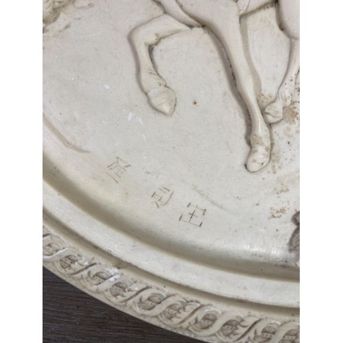 514 - A Chinese resin circular wall plaque depicting a horse and carriage - approx. 50cm diameter