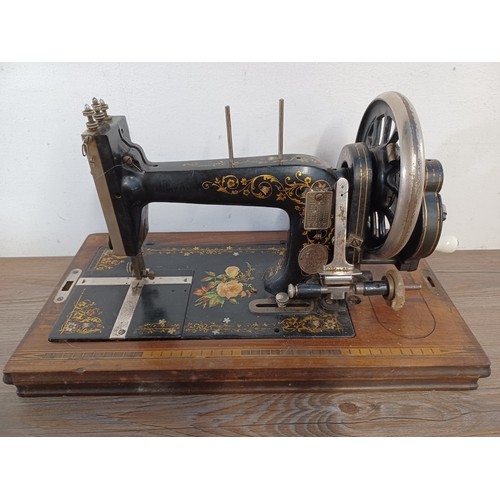 714 - A cased antique Winselmann No.1 hand crank sewing machine with attachments