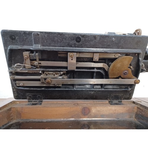 714 - A cased antique Winselmann No.1 hand crank sewing machine with attachments