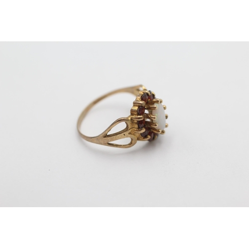 1001 - A 9ct gold opal and garnet halo dress ring, size M - approx. gross weight 2.2 grams