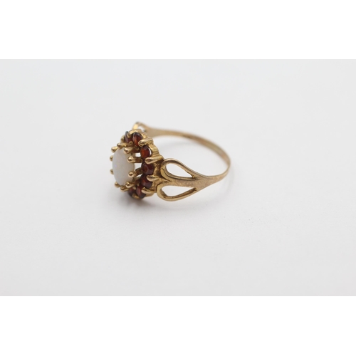 1001 - A 9ct gold opal and garnet halo dress ring, size M - approx. gross weight 2.2 grams