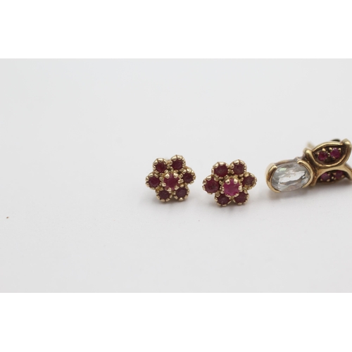 1010 - Two pairs of 9ct gold ruby gemstone stud earrings, one with topaz - approx. gross weight 2.8 grams