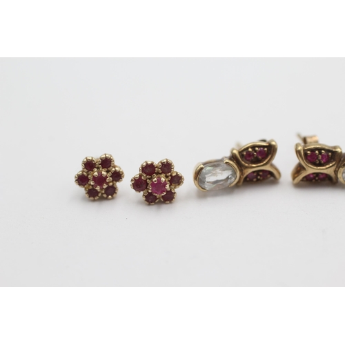 1010 - Two pairs of 9ct gold ruby gemstone stud earrings, one with topaz - approx. gross weight 2.8 grams