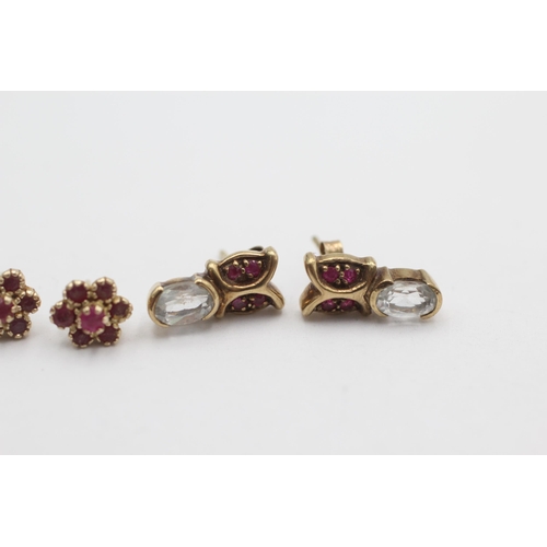 1010 - Two pairs of 9ct gold ruby gemstone stud earrings, one with topaz - approx. gross weight 2.8 grams