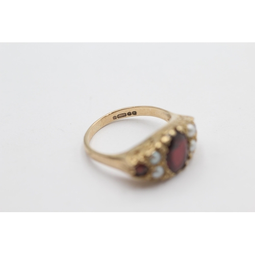 1023 - A 9ct gold garnet and pearl ornate gypsy setting ring, size N½ - approx. gross weight 4.1 grams