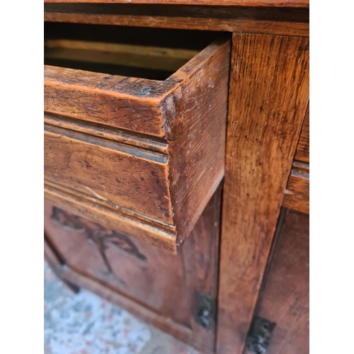 10 - An Art Nouveau carved oak sideboard with two drawers and two cupboard doors - approx. 93cm high x 12... 