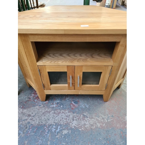 111 - A modern solid oak corner TV stand - approx. 63cm high x 94cm wide x 50cm deep