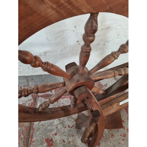 133 - A 19th century style beech spinning wheel - approx. 85cm high