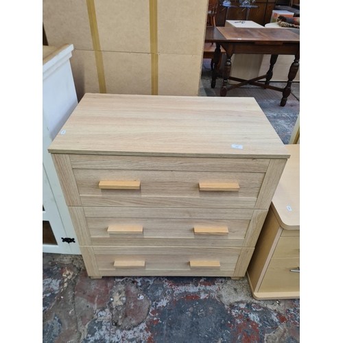 134 - A modern oak effect chest of three drawers - approx. 85cm high x 83cm wide x 50cm deep