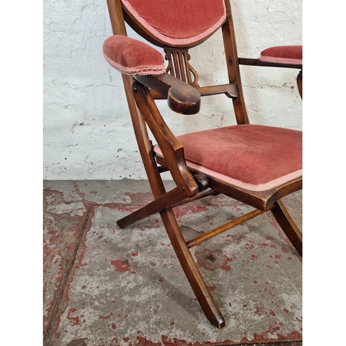 29 - An Edwardian beech and pink fabric upholstered folding armchair