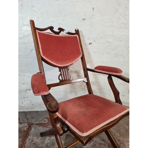 29 - An Edwardian beech and pink fabric upholstered folding armchair