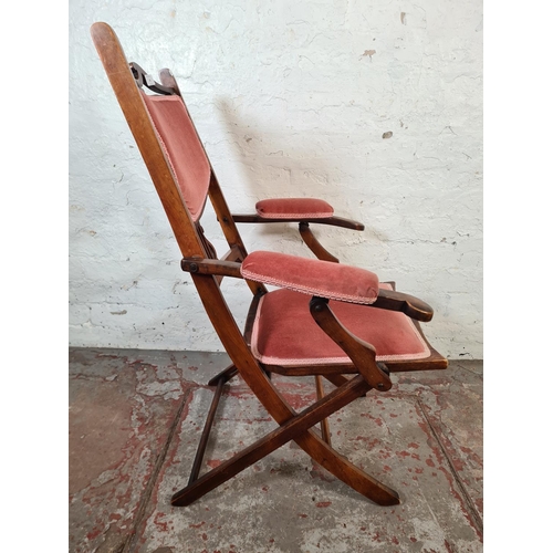 29 - An Edwardian beech and pink fabric upholstered folding armchair