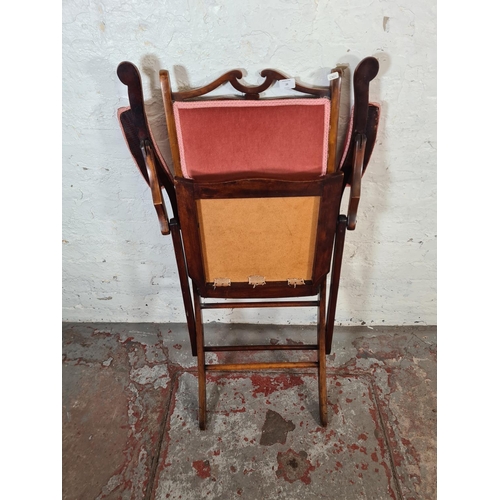 29 - An Edwardian beech and pink fabric upholstered folding armchair