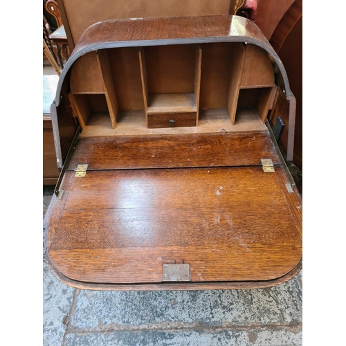 49 - An Art Deco oak bureau with fall front, two drawers and baluster supports