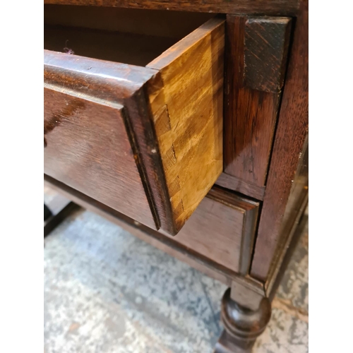 49 - An Art Deco oak bureau with fall front, two drawers and baluster supports