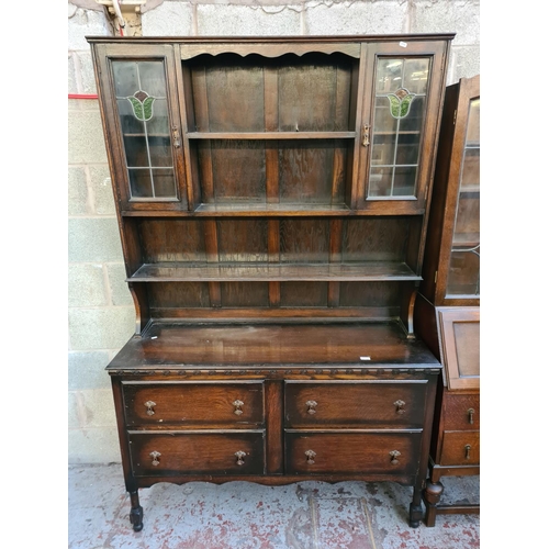 5 - A 1930s oak dresser with two stained and leaded glass doors and four drawers