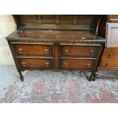 5 - A 1930s oak dresser with two stained and leaded glass doors and four drawers