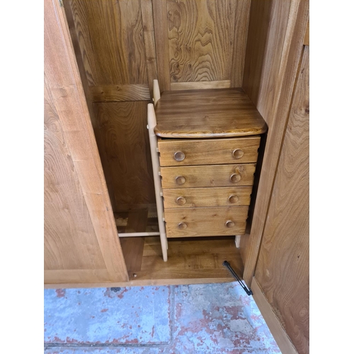 53 - An Ercol elm double wardrobe with four internal drawers (key in office) - approx. 182cm high x 121cm... 