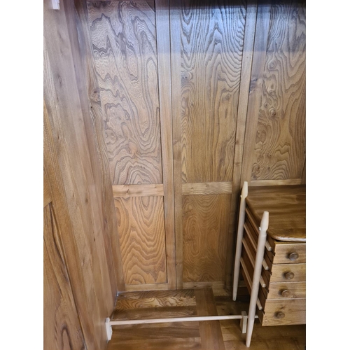 53 - An Ercol elm double wardrobe with four internal drawers (key in office) - approx. 182cm high x 121cm... 