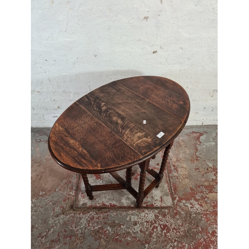 99 - An early 20th century oak drop leaf gate legged oval occasional table on barley twist supports - app... 