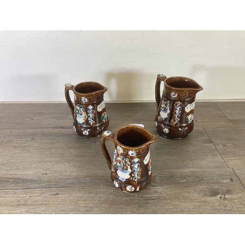 280 - Three 19th century treacle glazed earthenware graduating jugs