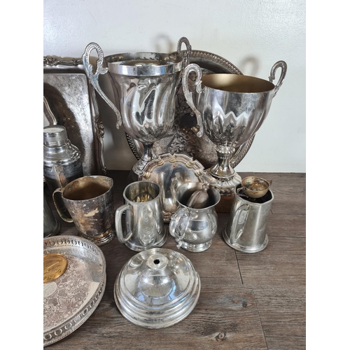 352 - A collection of metalware to include presentation trophies, cocktail shaker, trays etc.