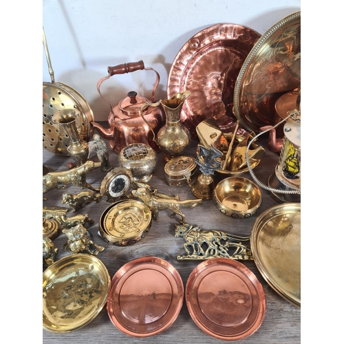 356 - A collection of metalware to include copper kettles, brass circular dishes, Lombard copper charger e... 