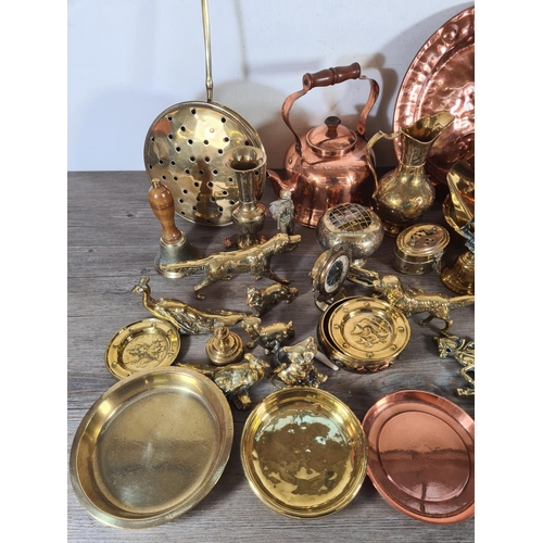 356 - A collection of metalware to include copper kettles, brass circular dishes, Lombard copper charger e... 