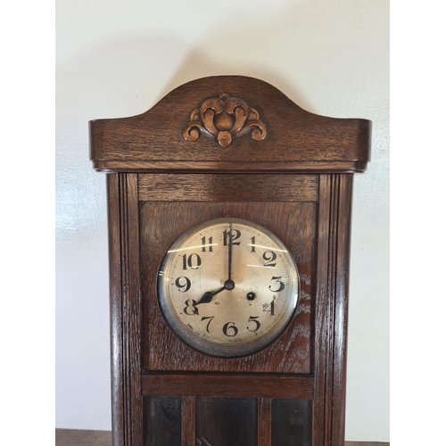 503 - A mid 20th century oak cased chiming wall clock with pendulum - approx. 78cm high x 33cm wide x 16cm... 