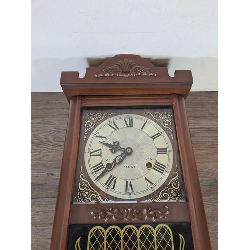 507 - A mid 20th century mahogany effect cased thirty one day chiming wall clock with pendulum and key - a... 