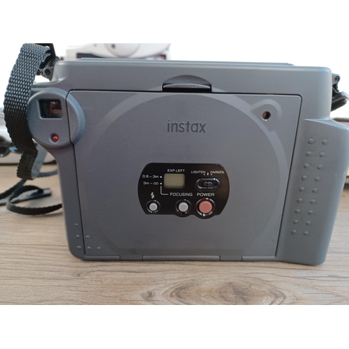 667 - Five items to include cased Fujifilm Instax 100 instant camera with instruction manual, boxed Polaro... 