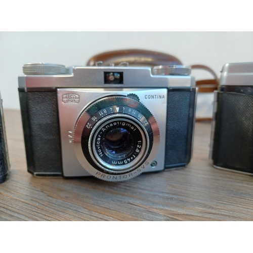 669 - Five 35mm cameras to include cased mid 1950s Zeiss Ikon Contina Ib fitted with Novicar-Anastigmat 1:... 